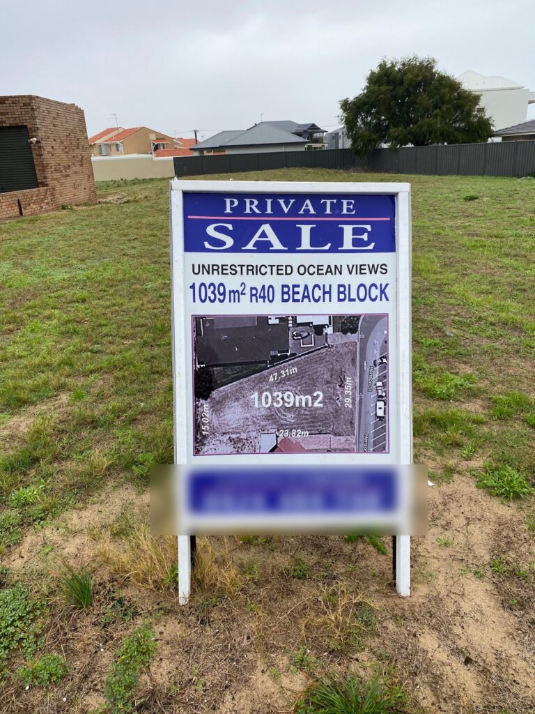 A private sale board advertising a beach block with ocean views, listed by the owner rather than an agent