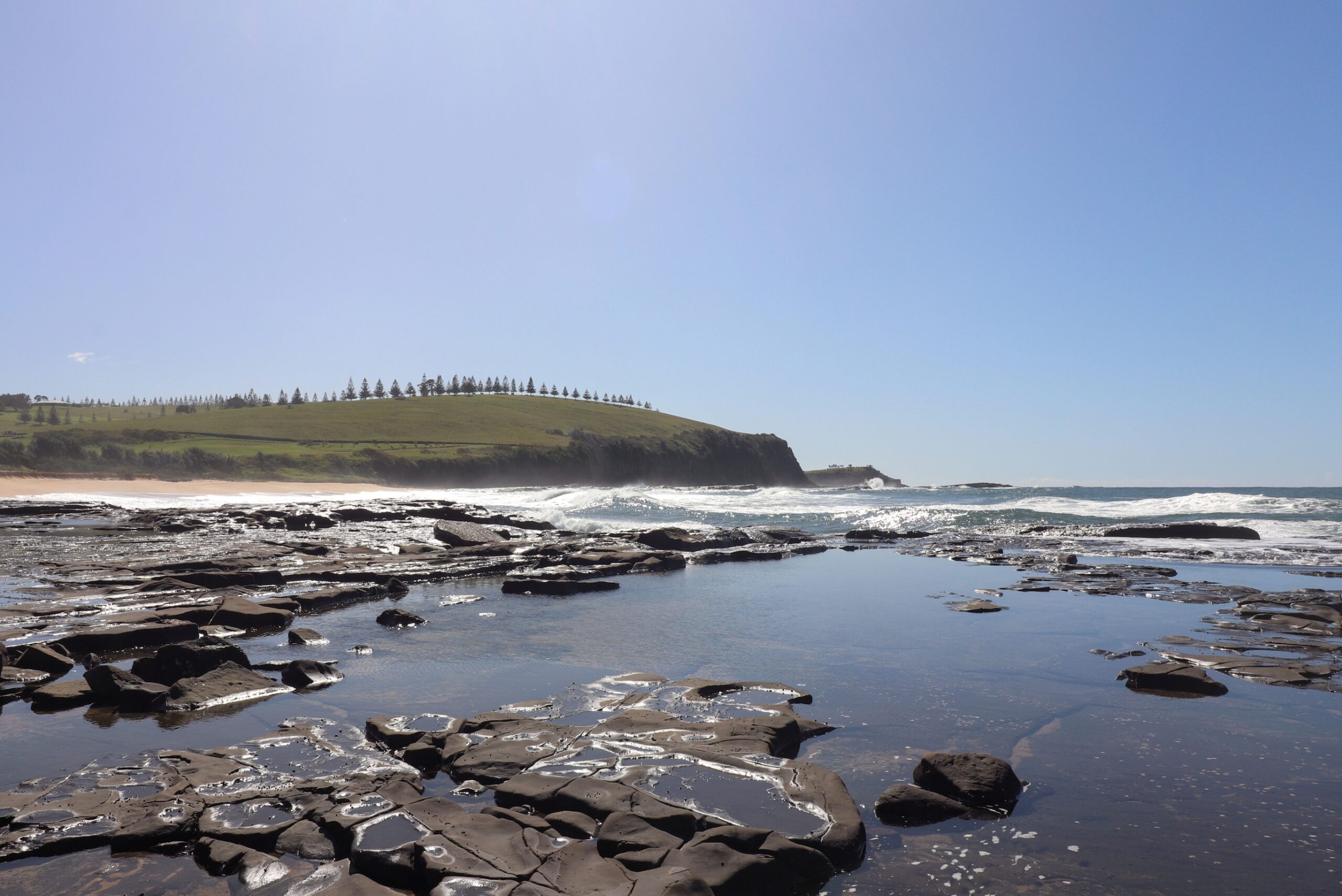 The rock shelf at Gerroa looking north to the grassy headland above the village