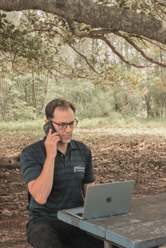Matt Knight of Precium on a client call at his laptop outdoors